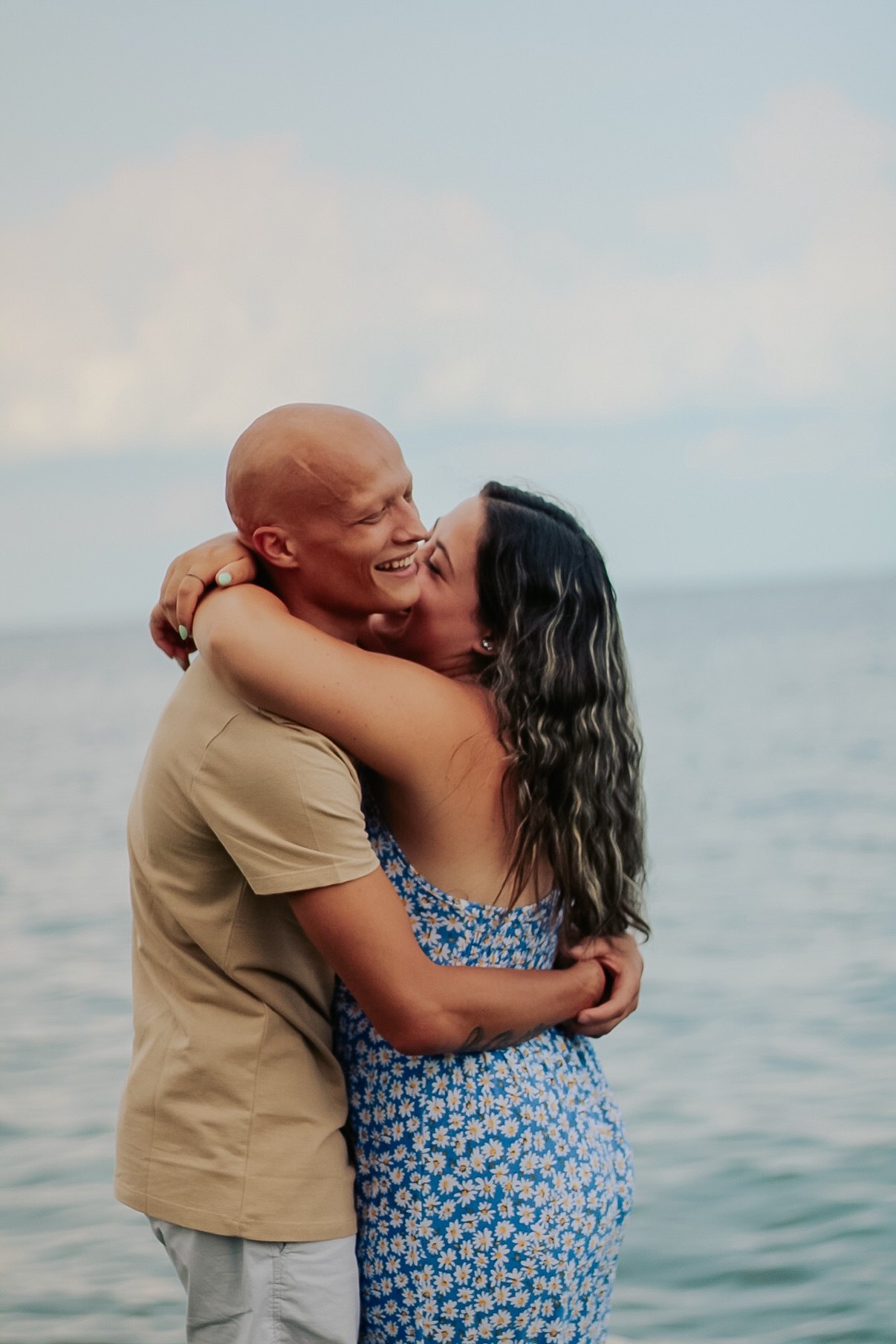 Couple hugging and laughing together by the water