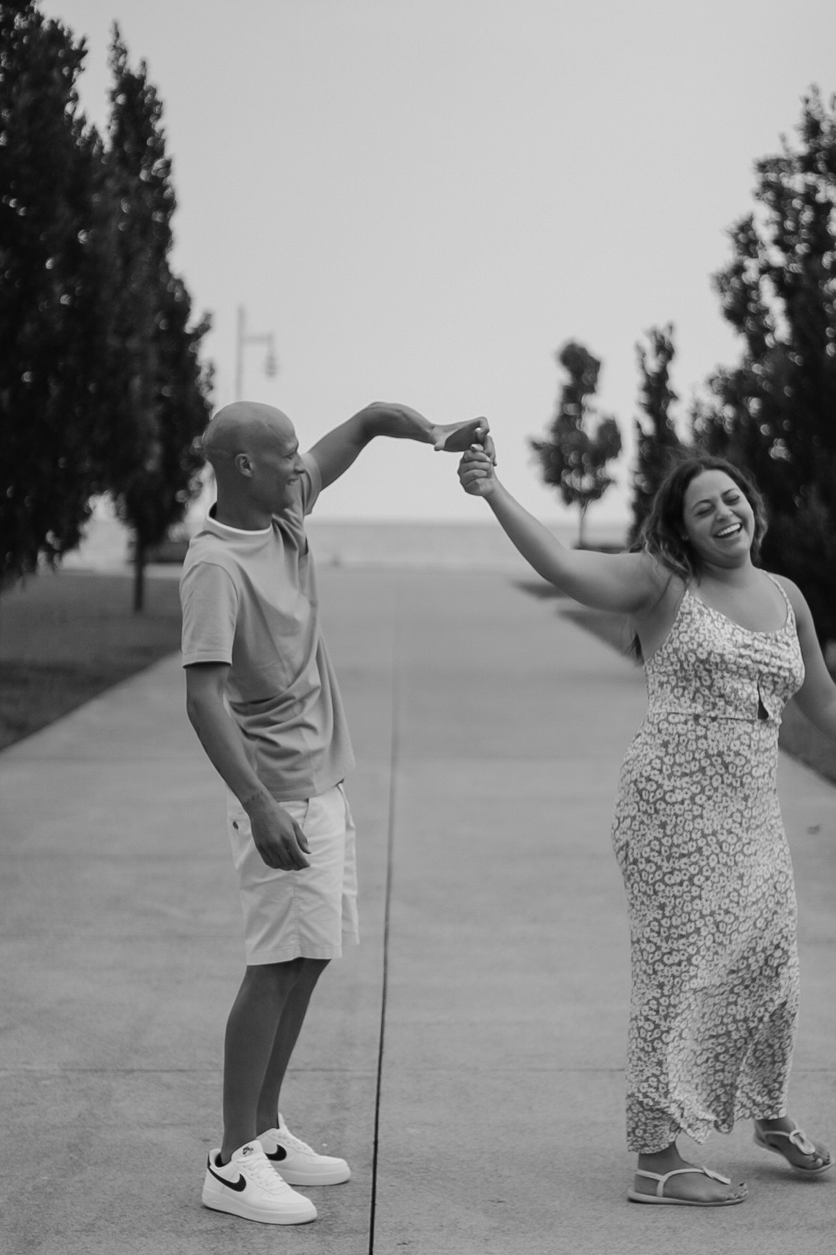 Black-and-white photo of a couple dancing together on a walkway